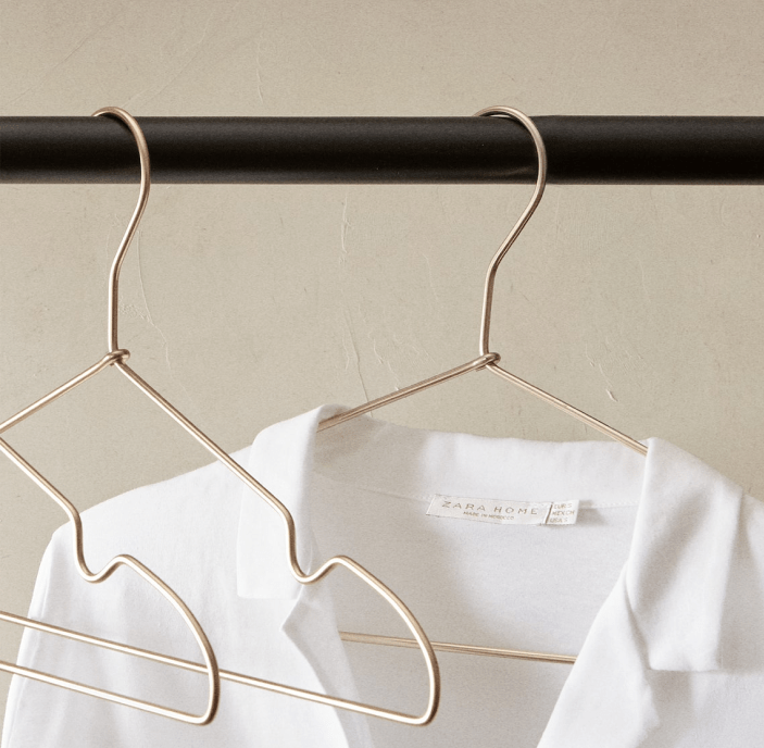 Image of 3 copper hangers with one of them hanging a white t-shirt